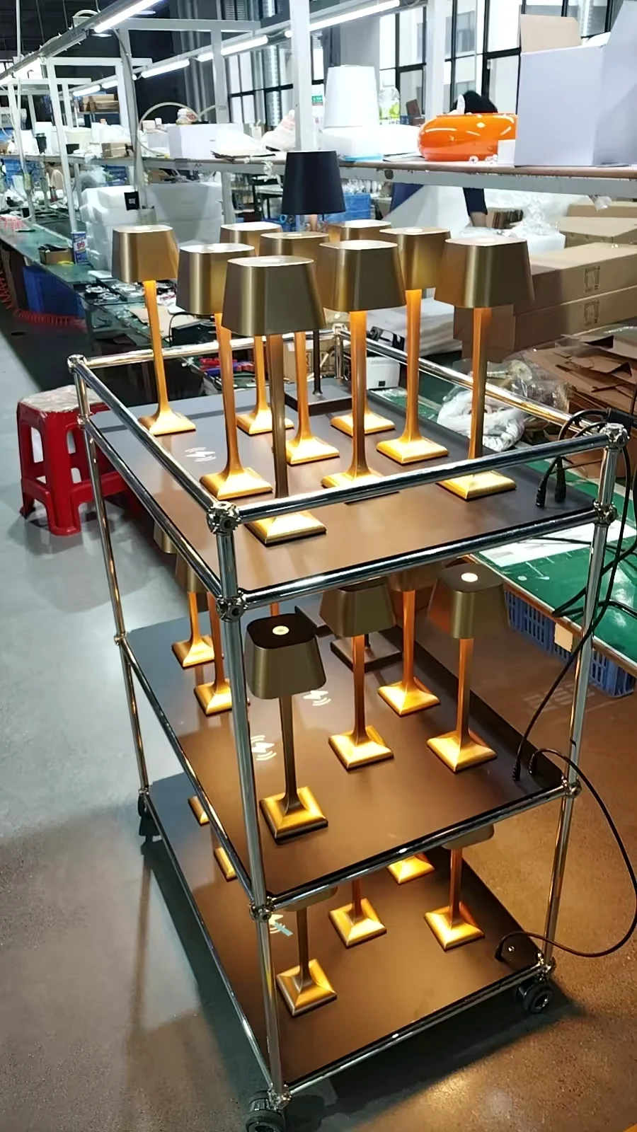 Front three-quarter view of the three-tier charging trolley with gold cordless lamps