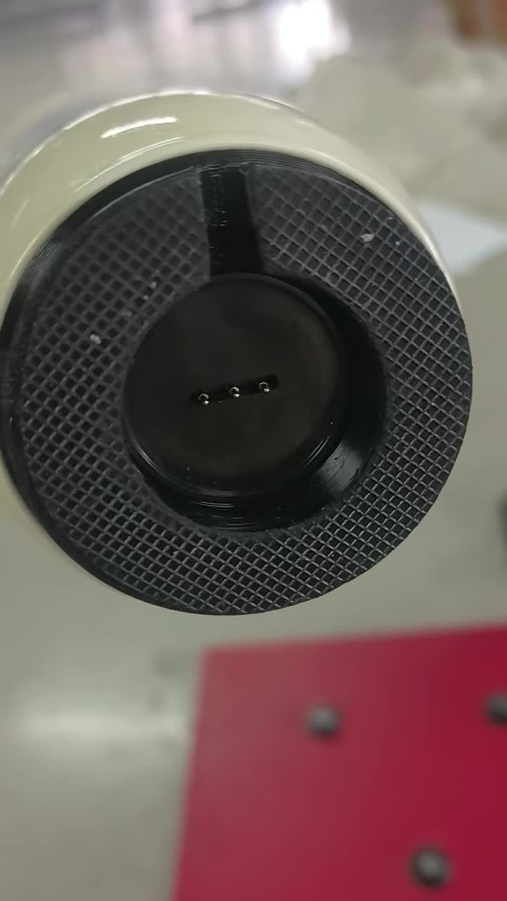 Real video frame showing a lamp underside with a recessed magnetic contact connection